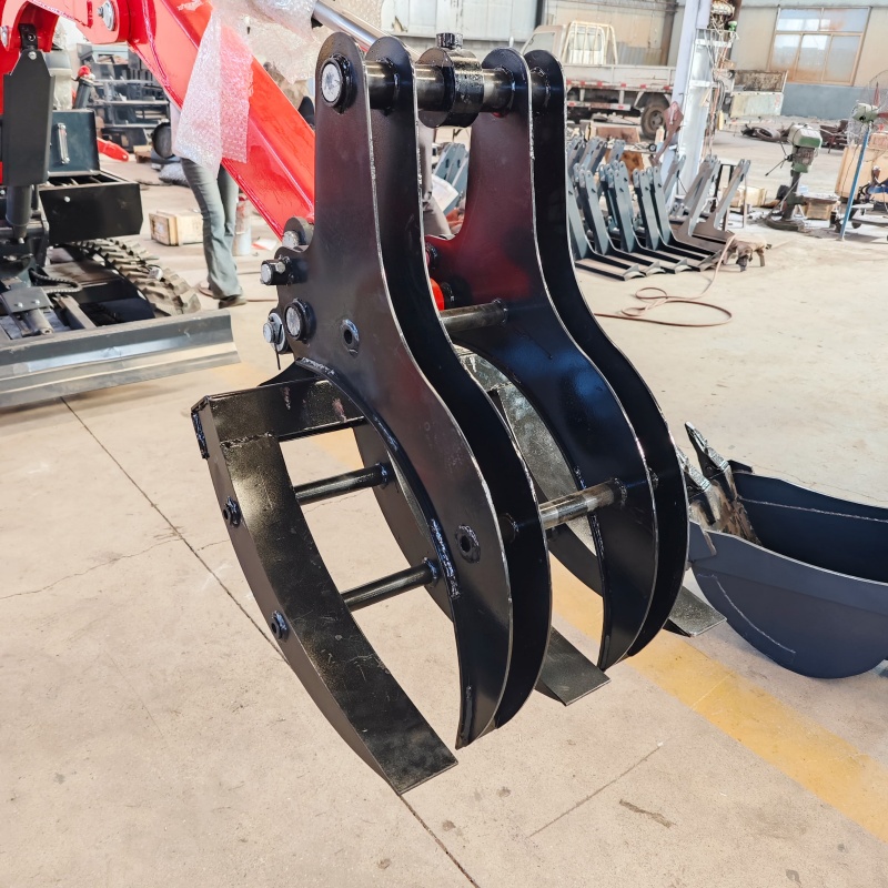 Small excavator equipped with loading attachments - log grab, small bucket, narrow bucket